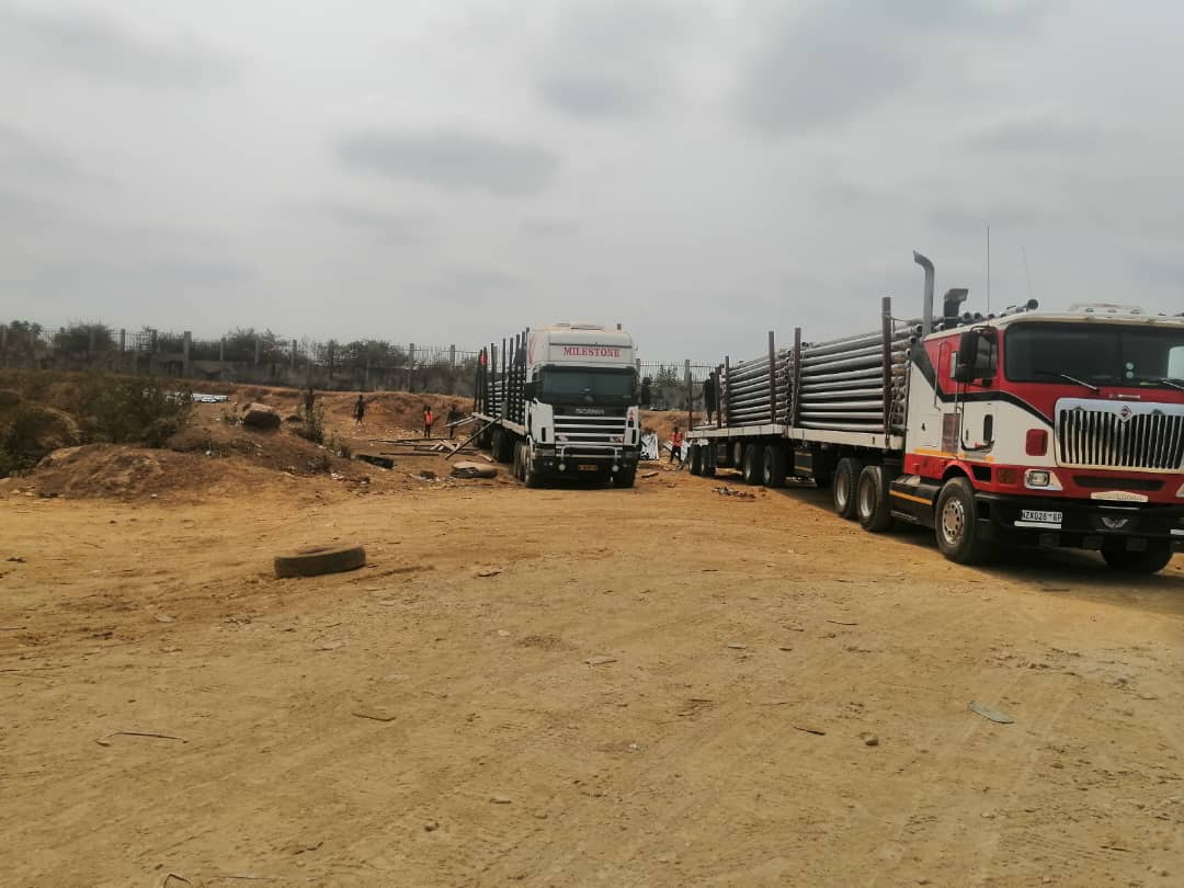 Two freight trucks loaded with long cargo